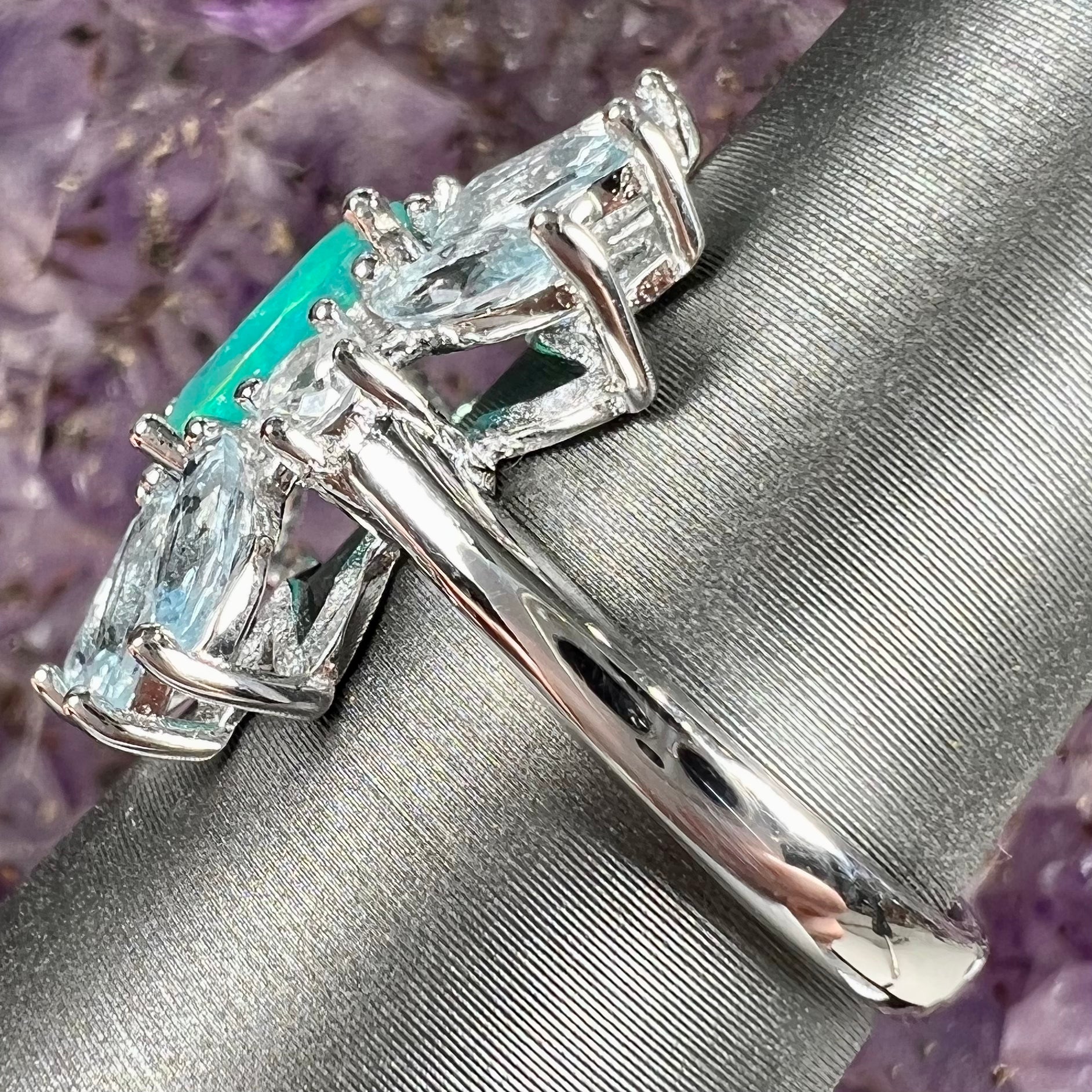 A faceted oval cut blue Ethiopian fire opal set in a sterling silver ring with marquise cut blue topaz stones.
