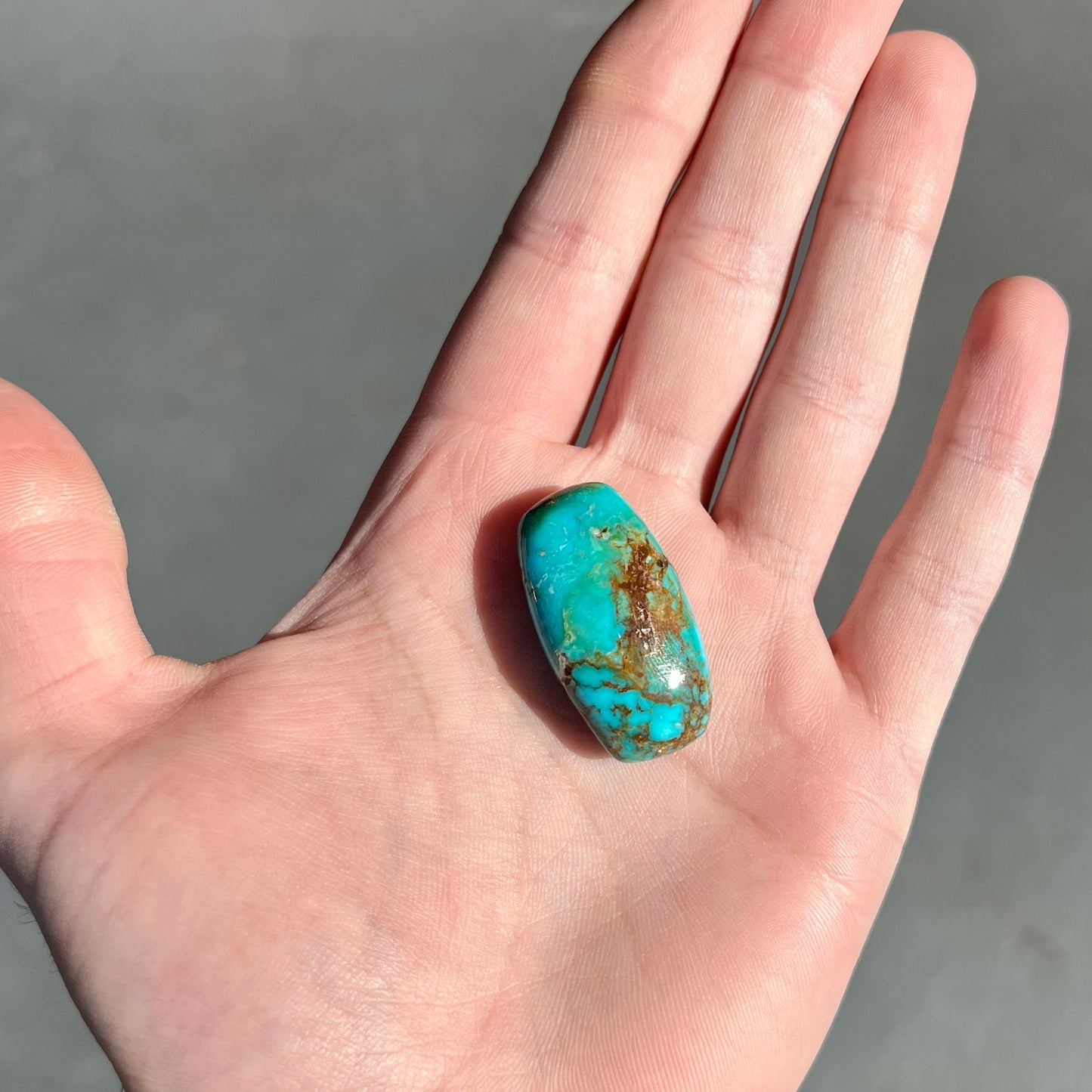 A loose, polished cabochon cut turquoise stone from Royston Mining District, Nevada.