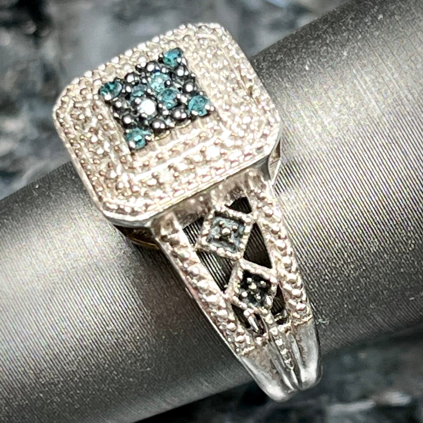 A sterling silver ring set with blue and white diamonds.