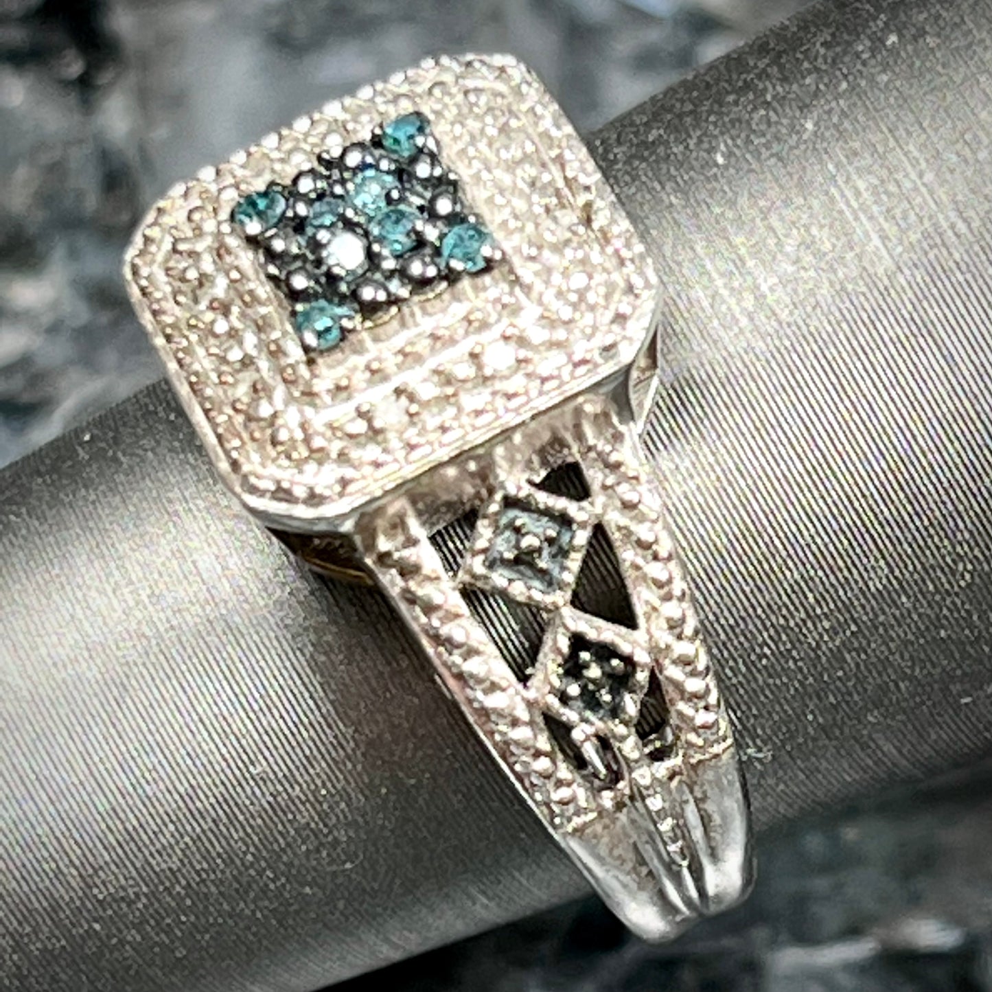 A sterling silver ring set with blue and white diamonds.