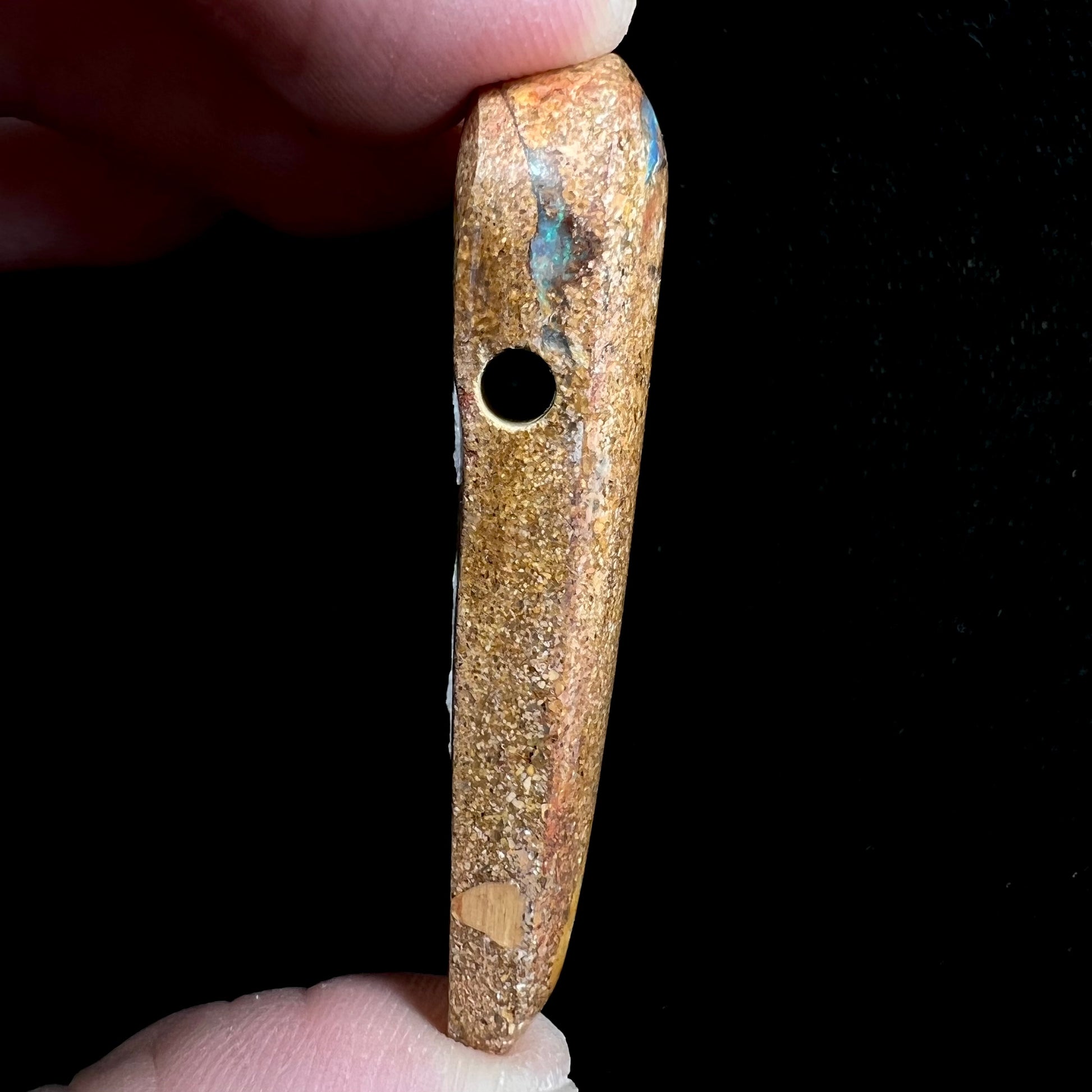 A polished, drilled pipe boulder opal bead.