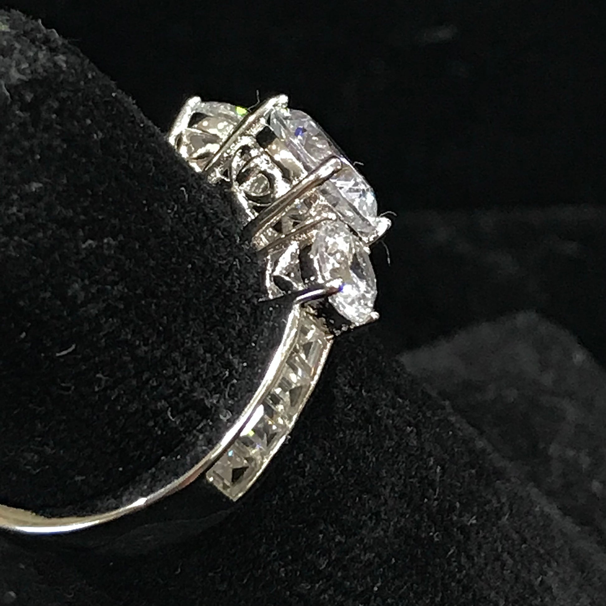 A sterling silver ring set with three round cut cubic zirconia stones.