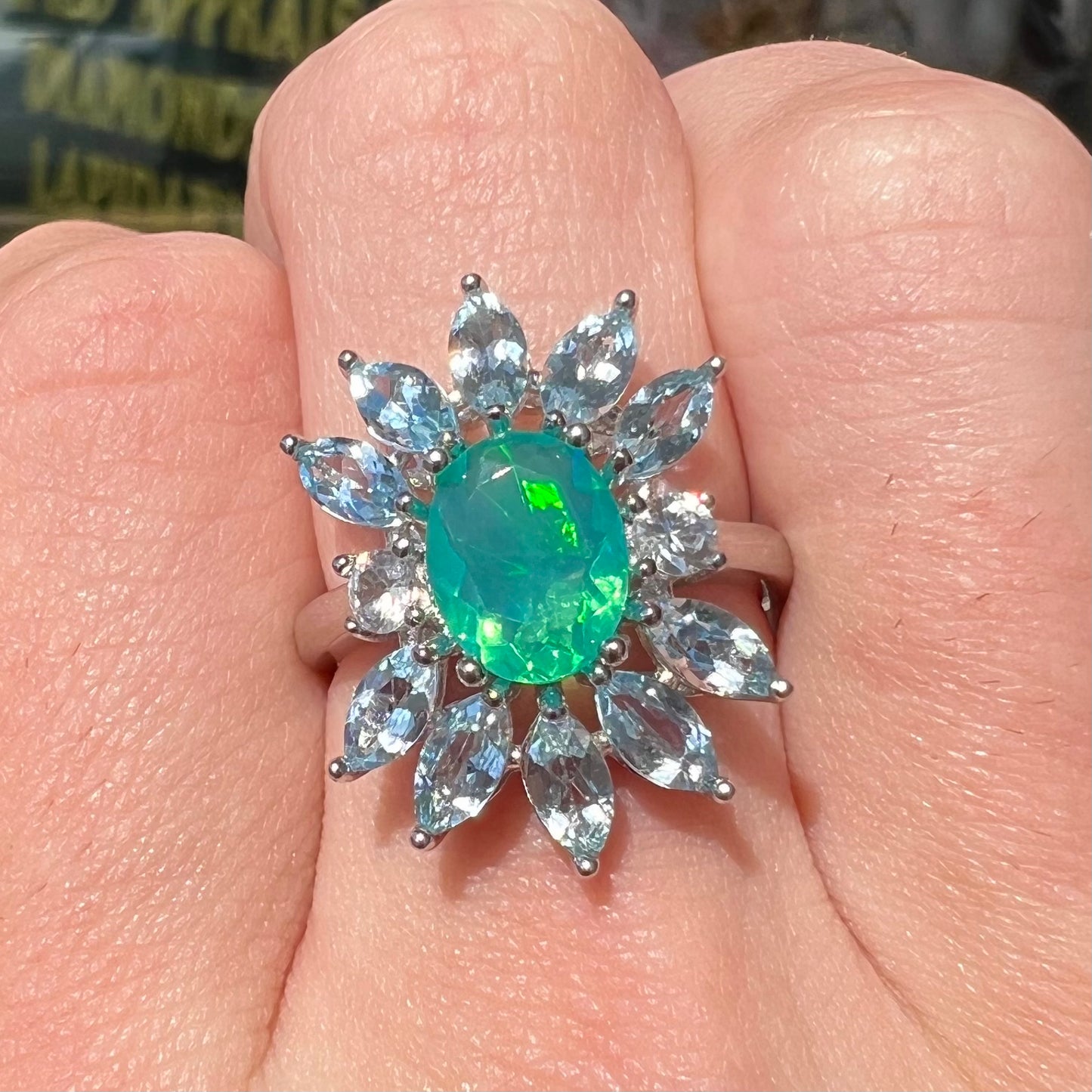 A faceted oval cut blue Ethiopian fire opal set in a sterling silver ring with marquise cut blue topaz stones.