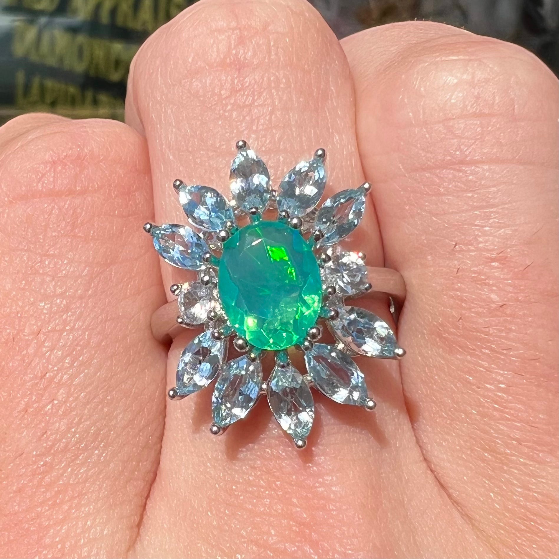 A faceted oval cut blue Ethiopian fire opal set in a sterling silver ring with marquise cut blue topaz stones.