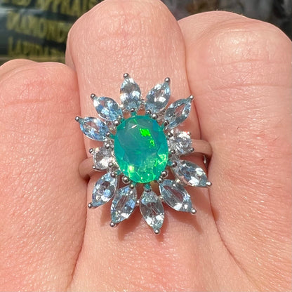 A faceted oval cut blue Ethiopian fire opal set in a sterling silver ring with marquise cut blue topaz stones.