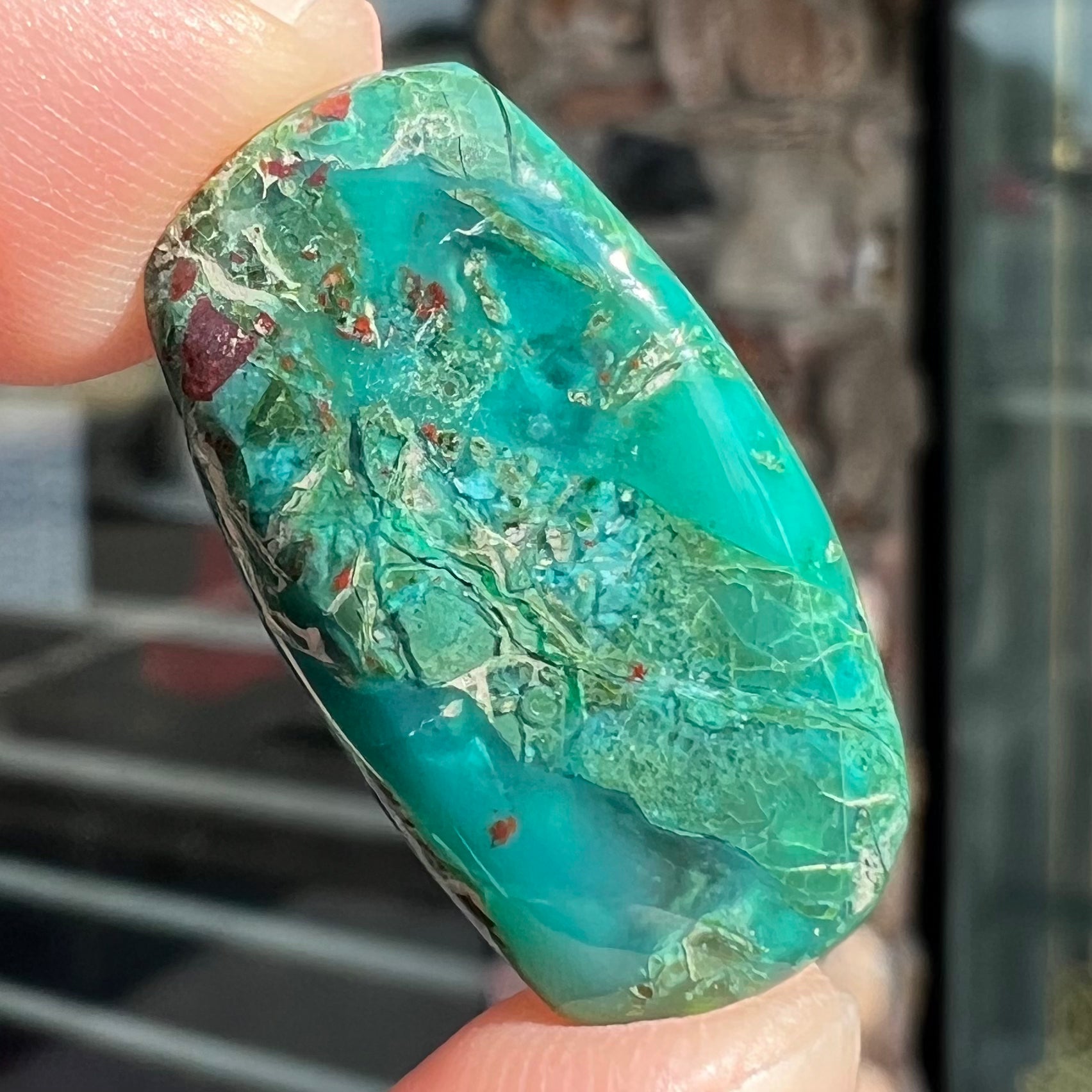 A loose, green, barrel cabochon shaped chrysocolla stone from Morenci, Arizona.