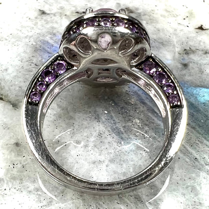 A sterling silver oval cut kunzite ring set with a double halo of round cut CZ and amethysts.