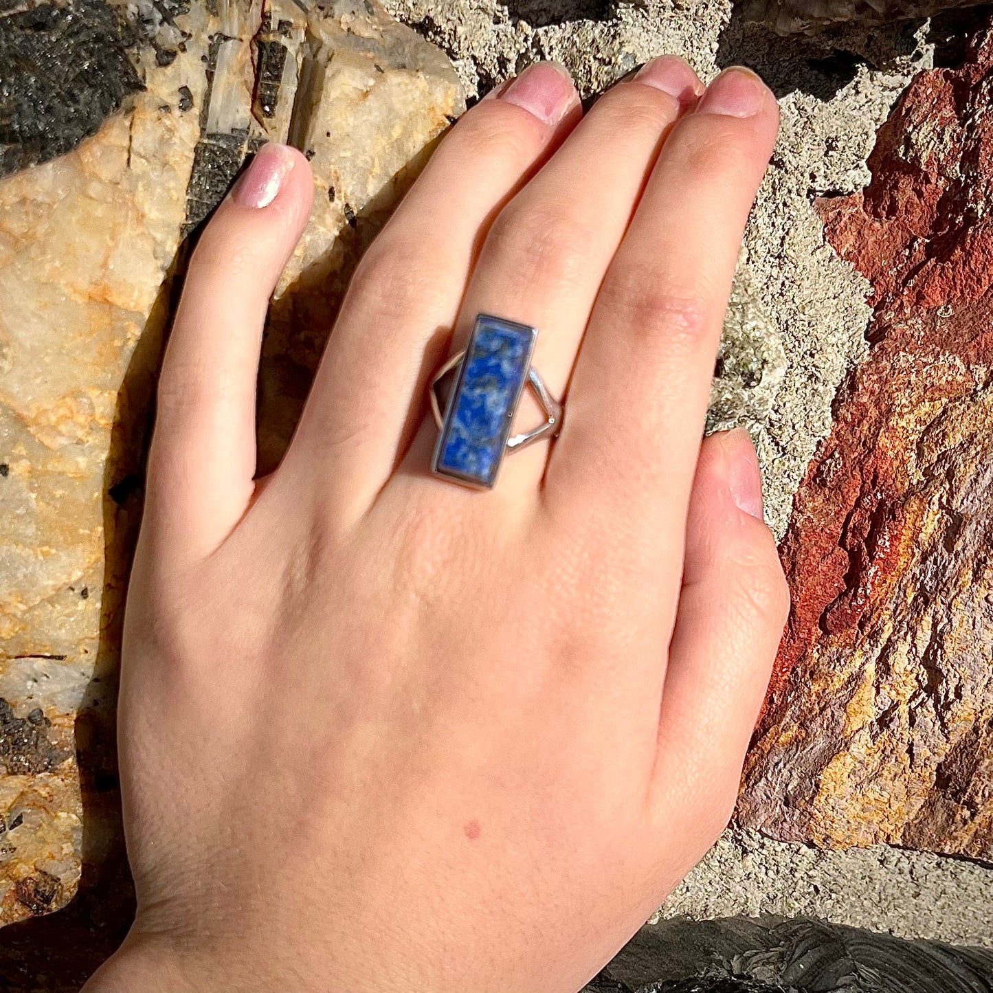 A split shank silver rectangular cabochon cut lapis lazuli ring.