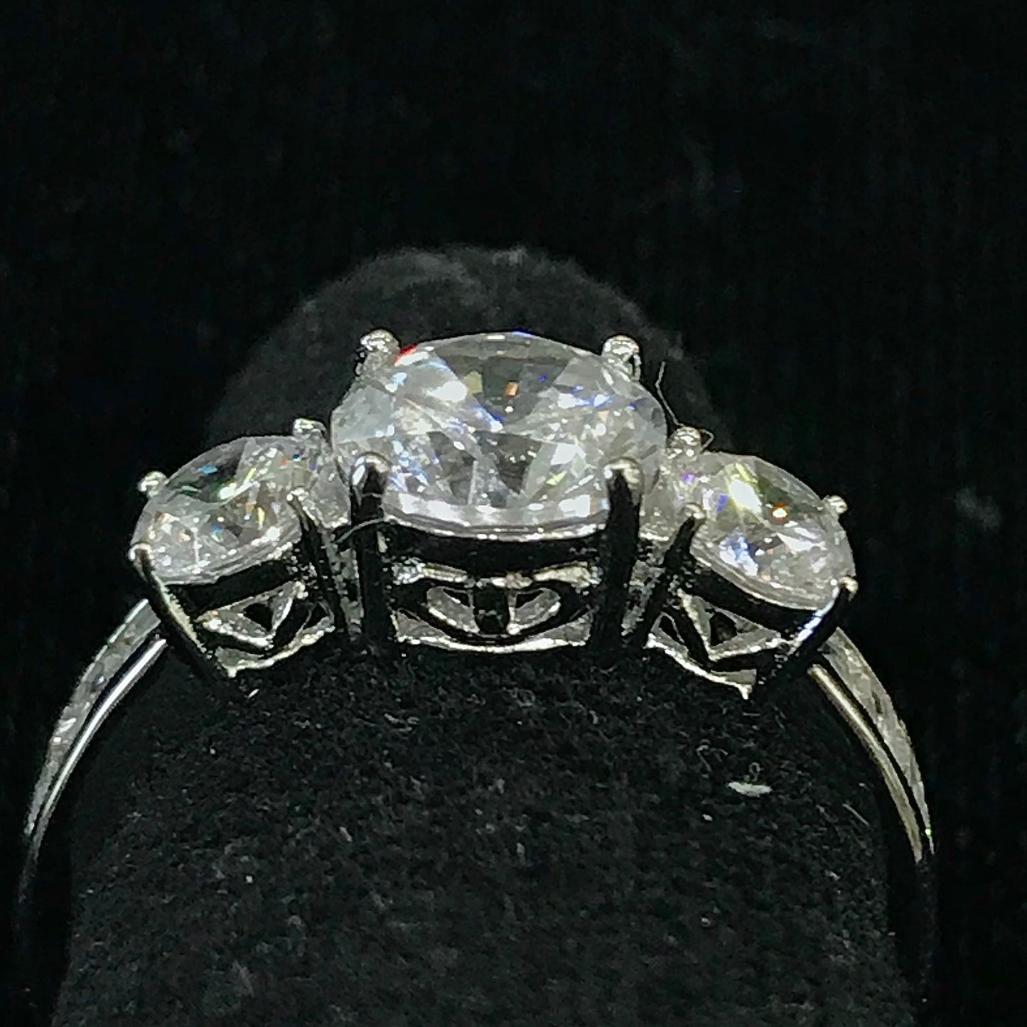 A sterling silver ring set with three round cut cubic zirconia stones.