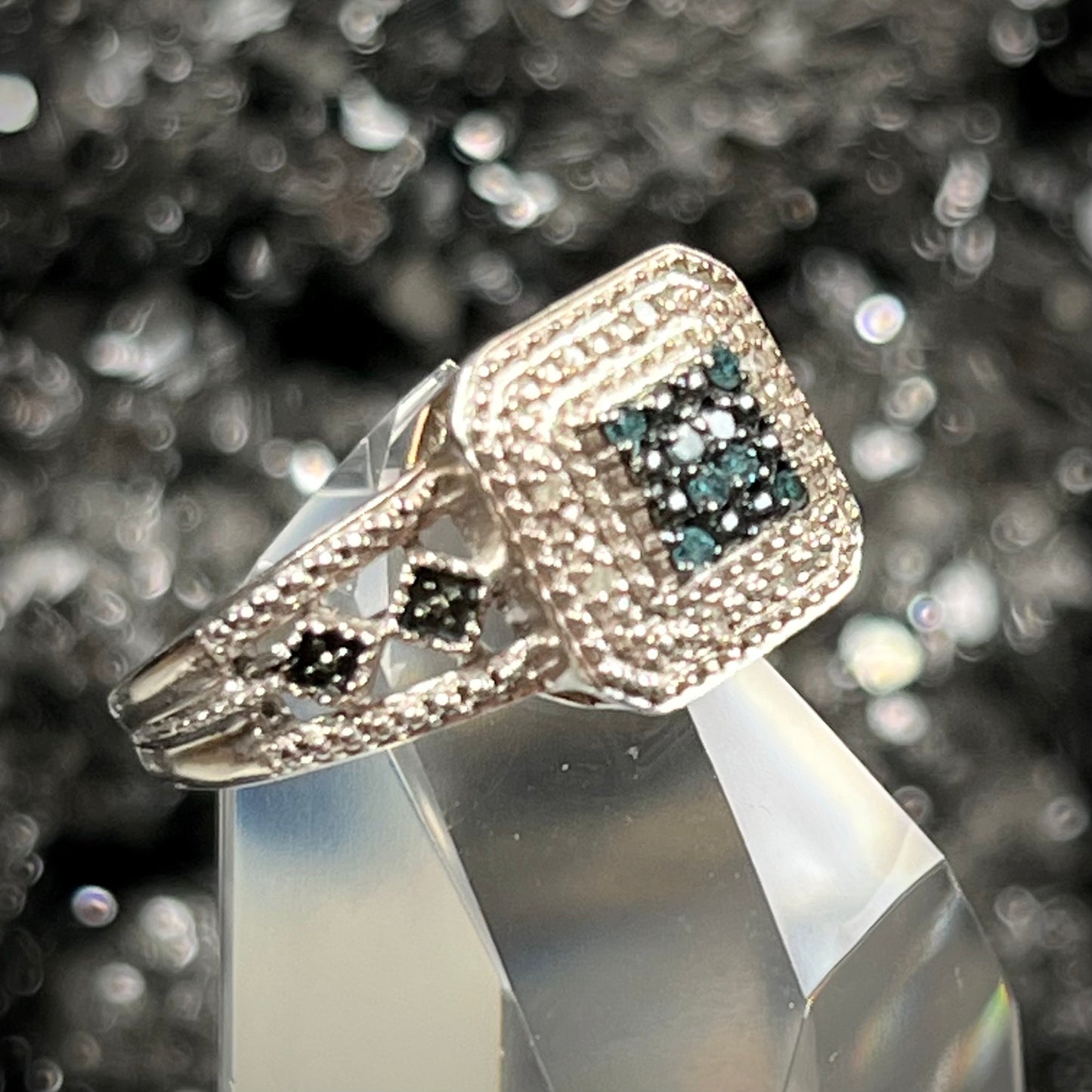 A sterling silver ring set with blue and white diamonds.