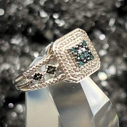 A sterling silver ring set with blue and white diamonds.
