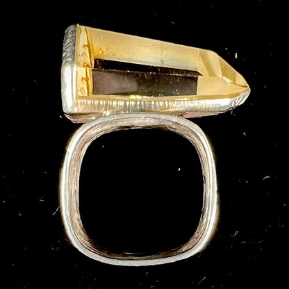 A sterling silver ring set with a naturally terminated yellow citrine quartz crystal.