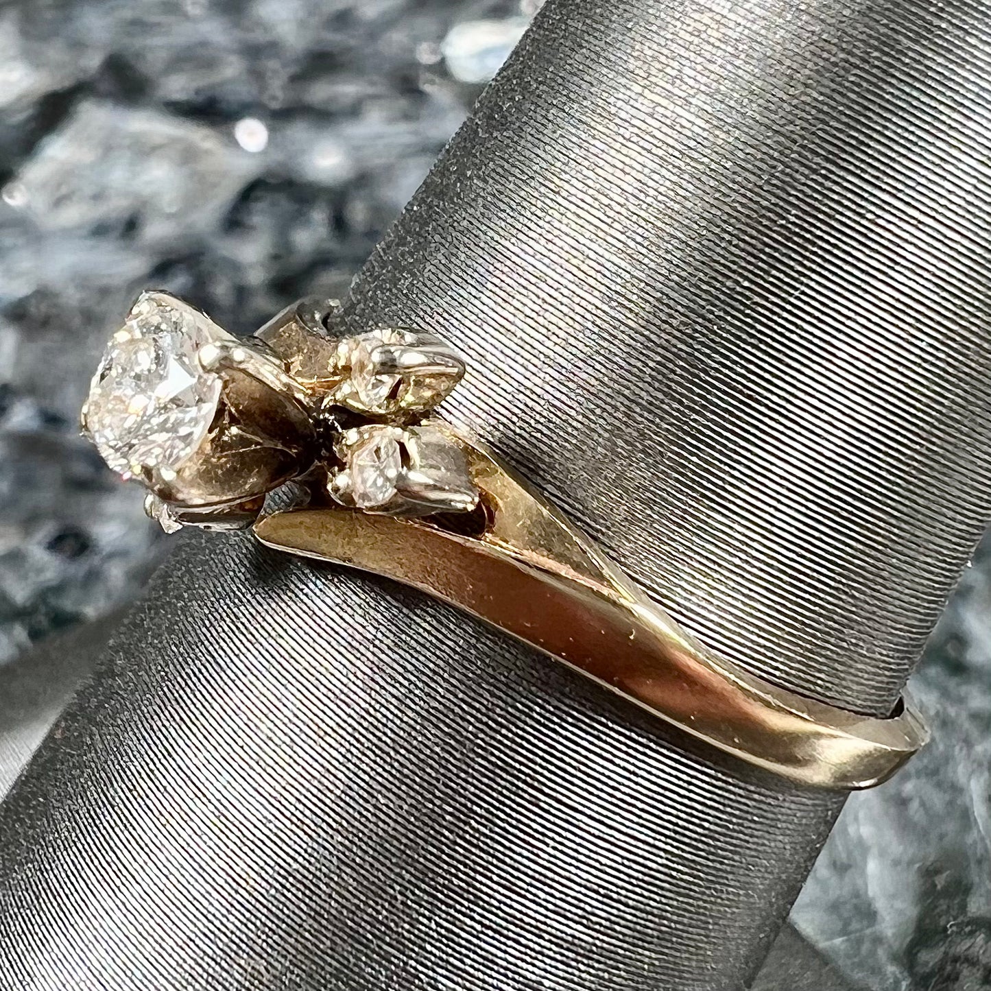 A yellow gold high-set diamond ring with four side diamonds.