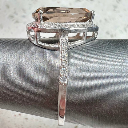 A pear shape smoky quartz set in a sterling silver and CZ halo ring.