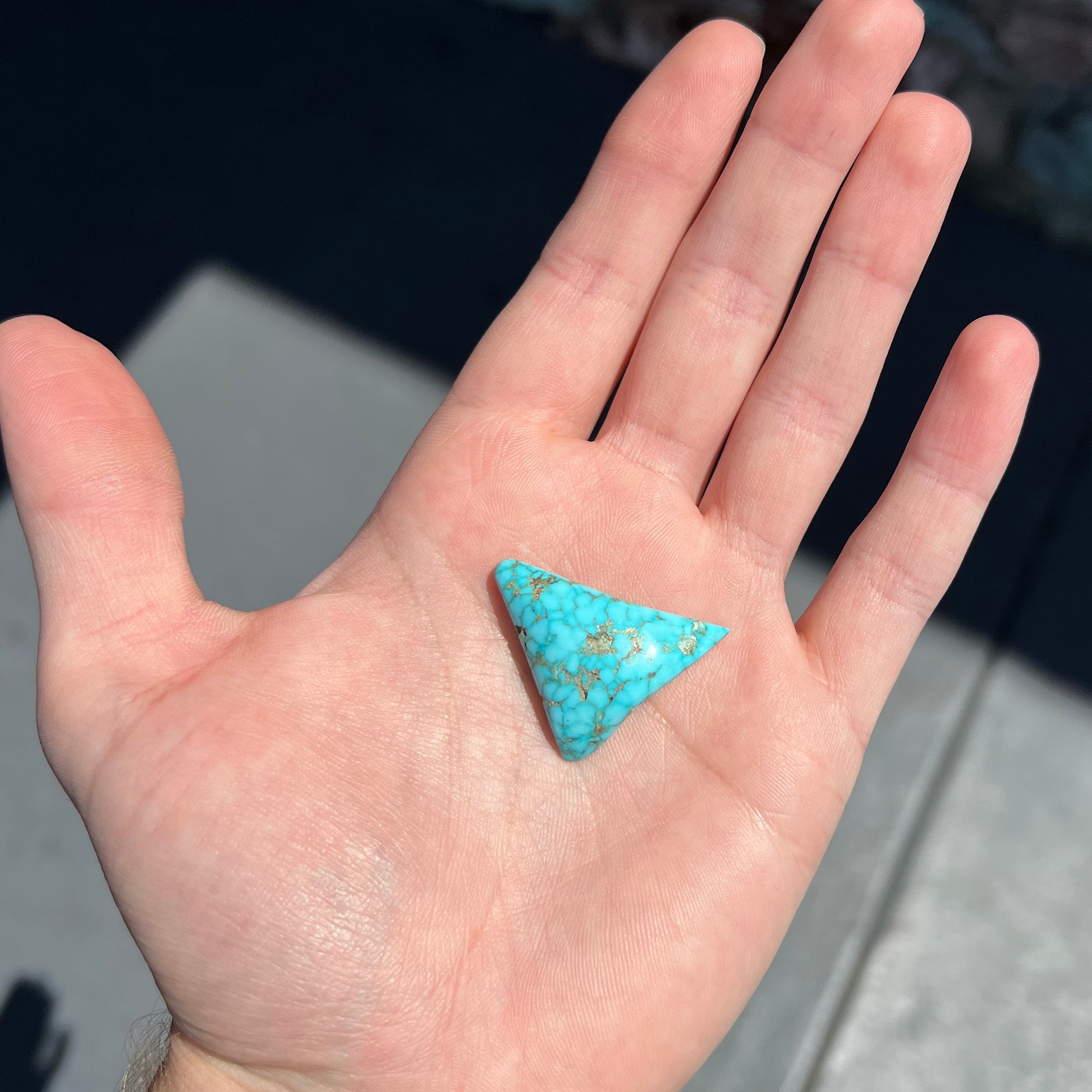 A polished triangular specimen of Bisbee, Arizona turquoise.