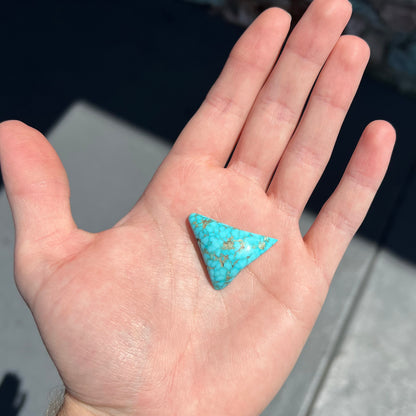 A polished triangular specimen of Bisbee, Arizona turquoise.