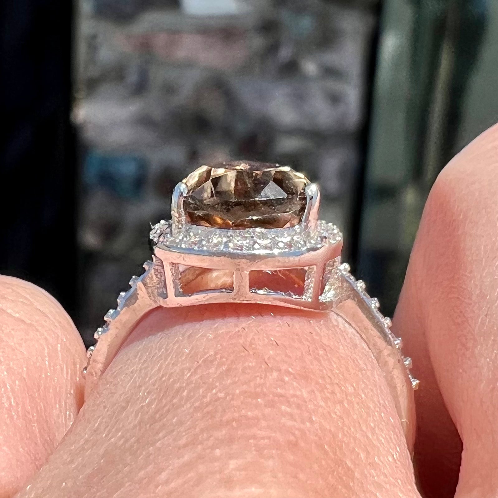 A pear shape smoky quartz set in a sterling silver and CZ halo ring.