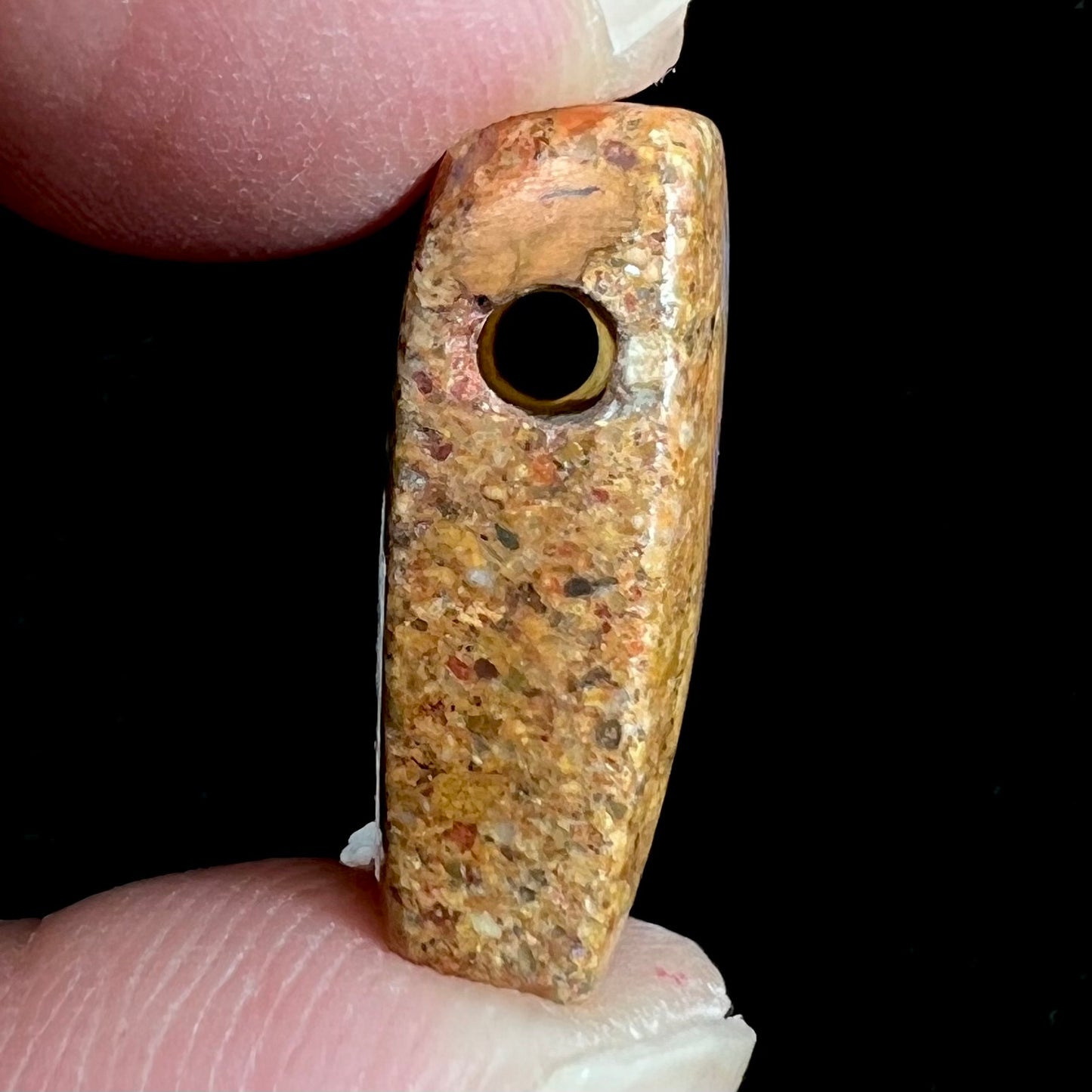 A polished, drilled pipe boulder opal bead.