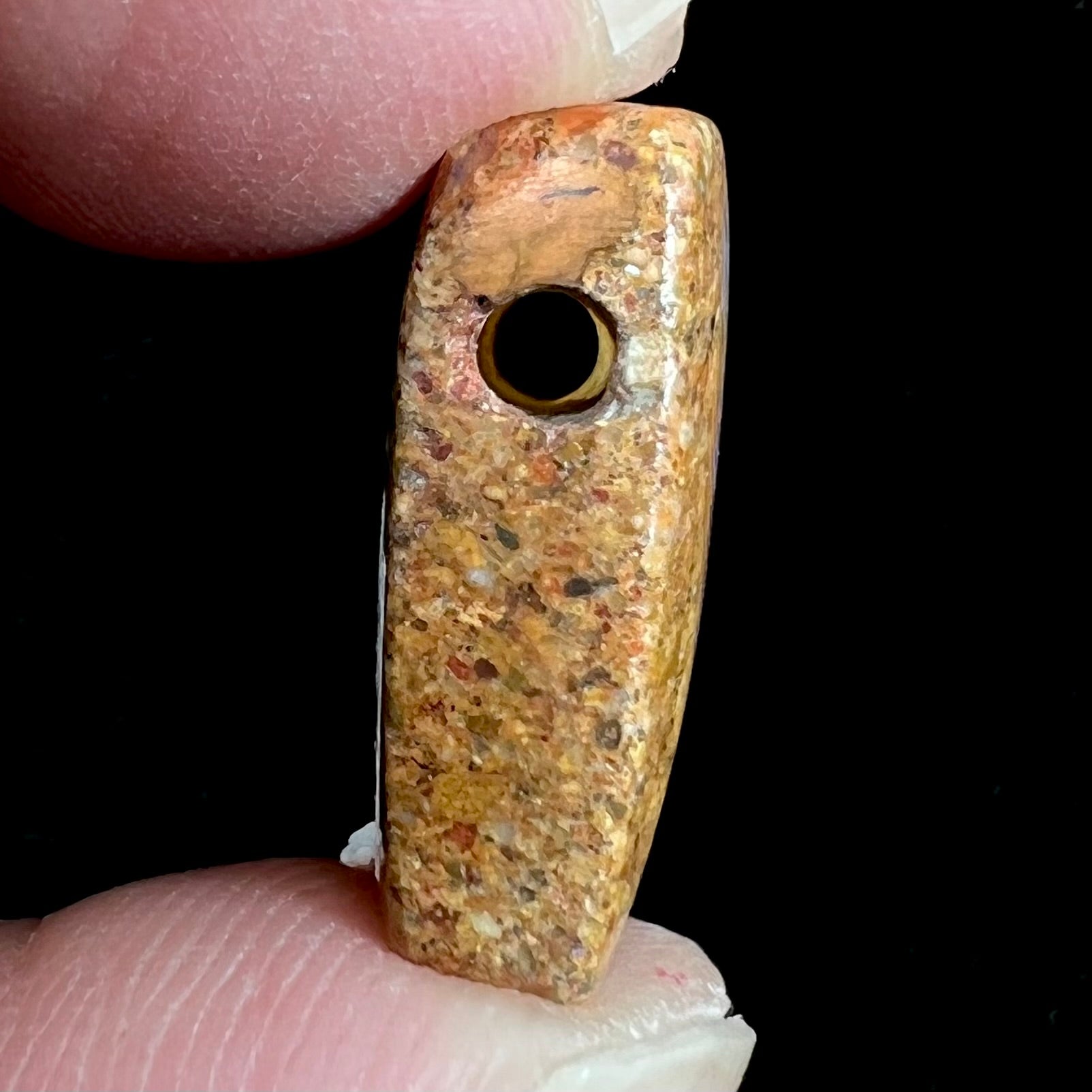A polished, drilled pipe boulder opal bead.