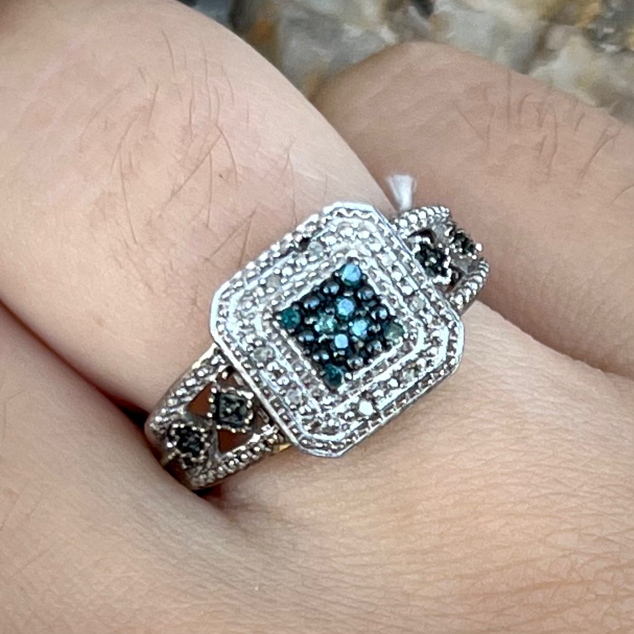 A sterling silver ring set with blue and white diamonds.