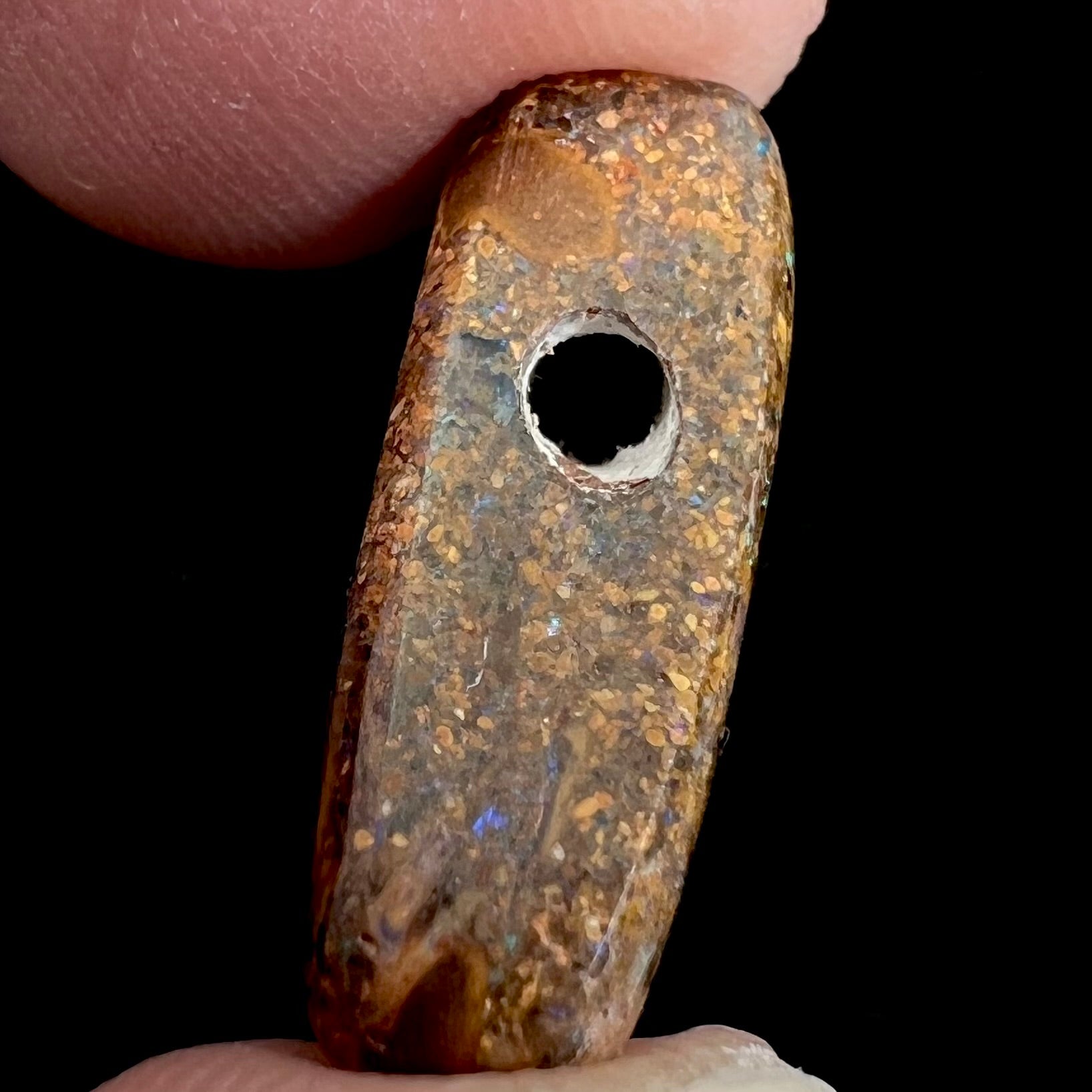 A polished, drilled pipe boulder opal bead.