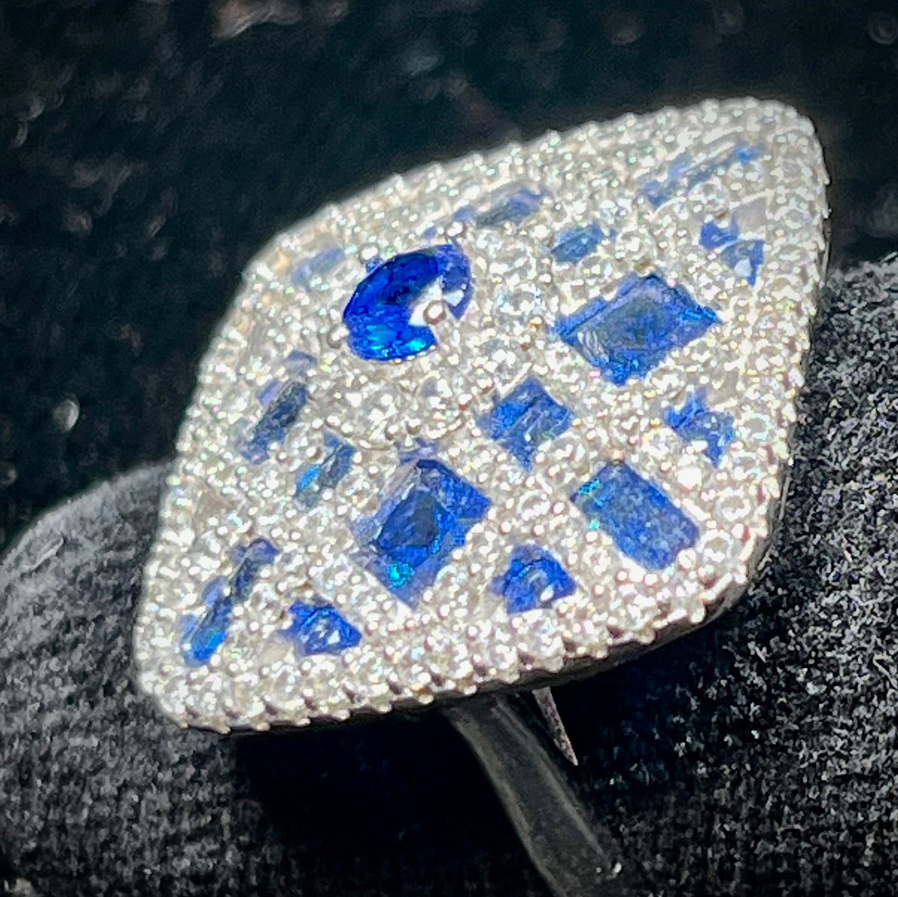 A sterling silver blue and white synthetic stone ring.  The ring strongly resembles a blueberry pie.