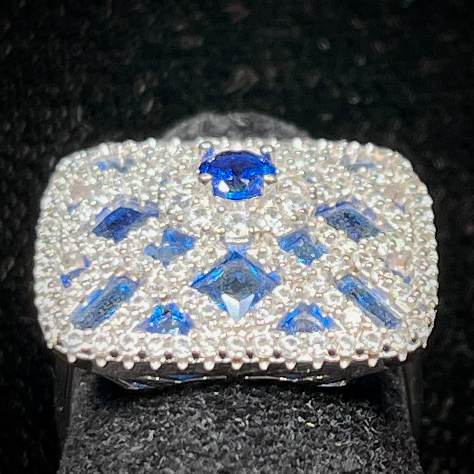 A sterling silver blue and white synthetic stone ring.  The ring strongly resembles a blueberry pie.