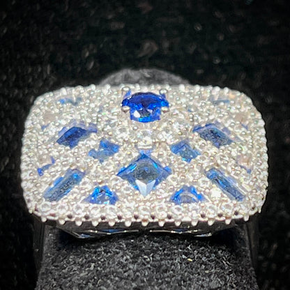 A sterling silver blue and white synthetic stone ring.  The ring strongly resembles a blueberry pie.