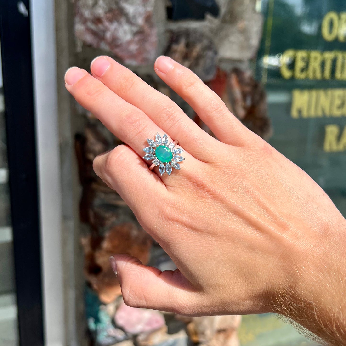 A faceted oval cut blue Ethiopian fire opal set in a sterling silver ring with marquise cut blue topaz stones.