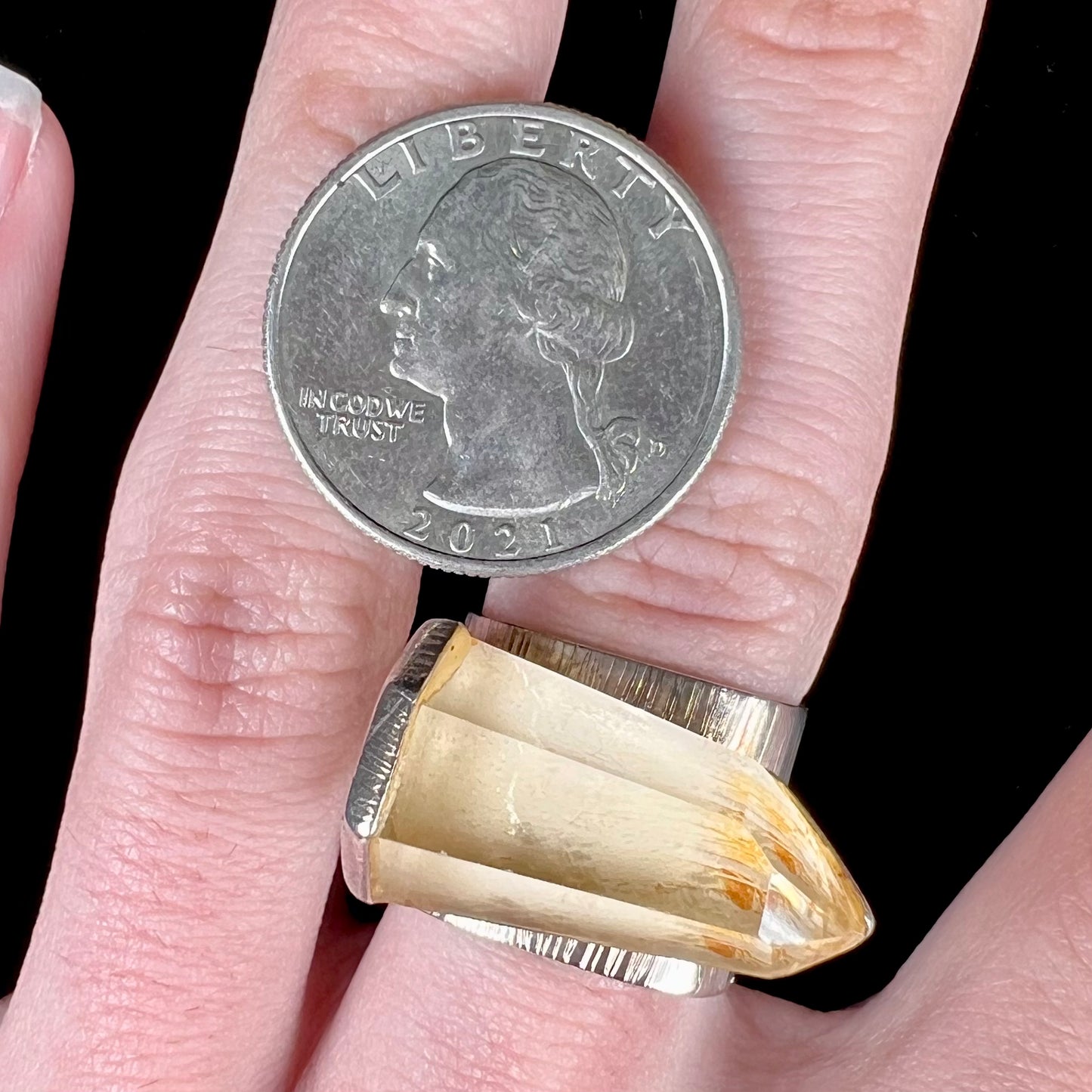 A sterling silver ring set with a naturally terminated yellow citrine quartz crystal.