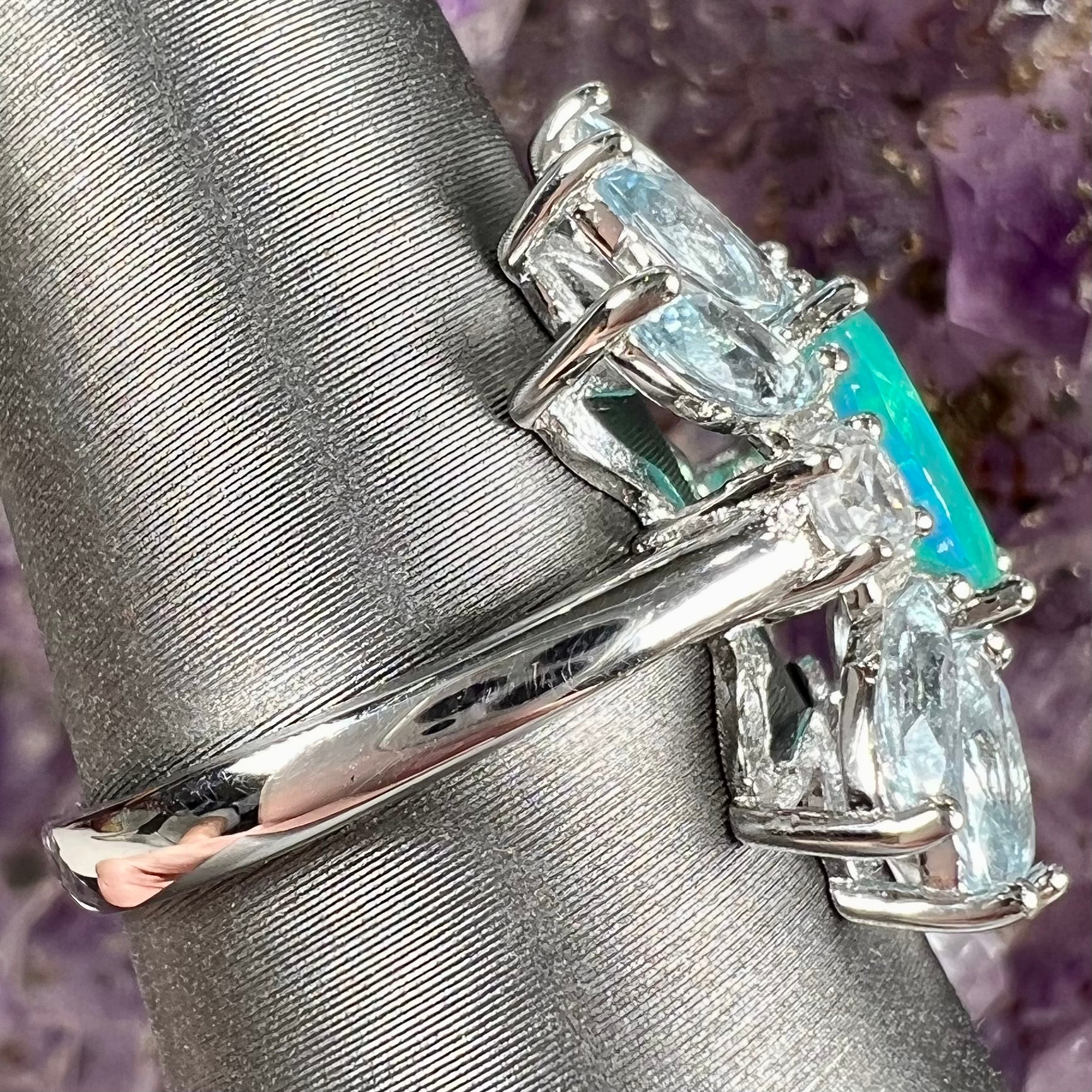 A faceted oval cut blue Ethiopian fire opal set in a sterling silver ring with marquise cut blue topaz stones.