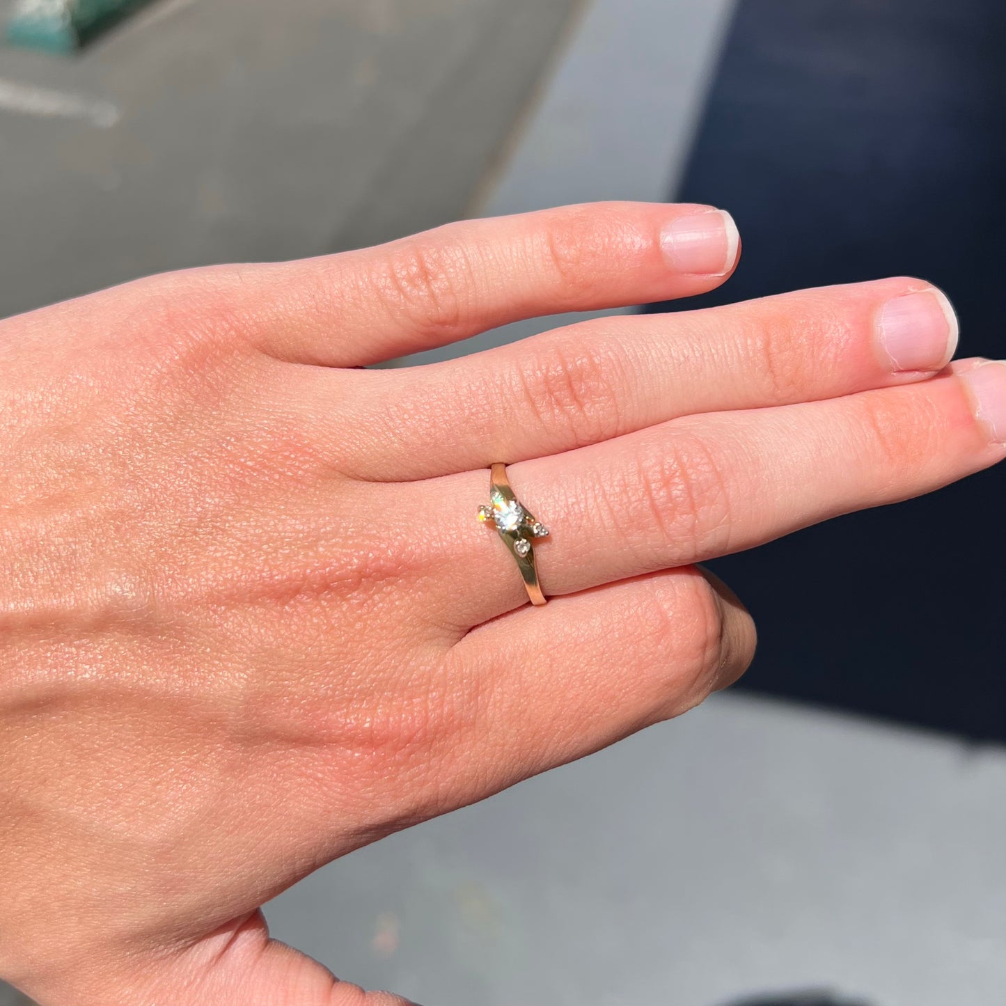 A yellow gold high-set diamond ring with four side diamonds.