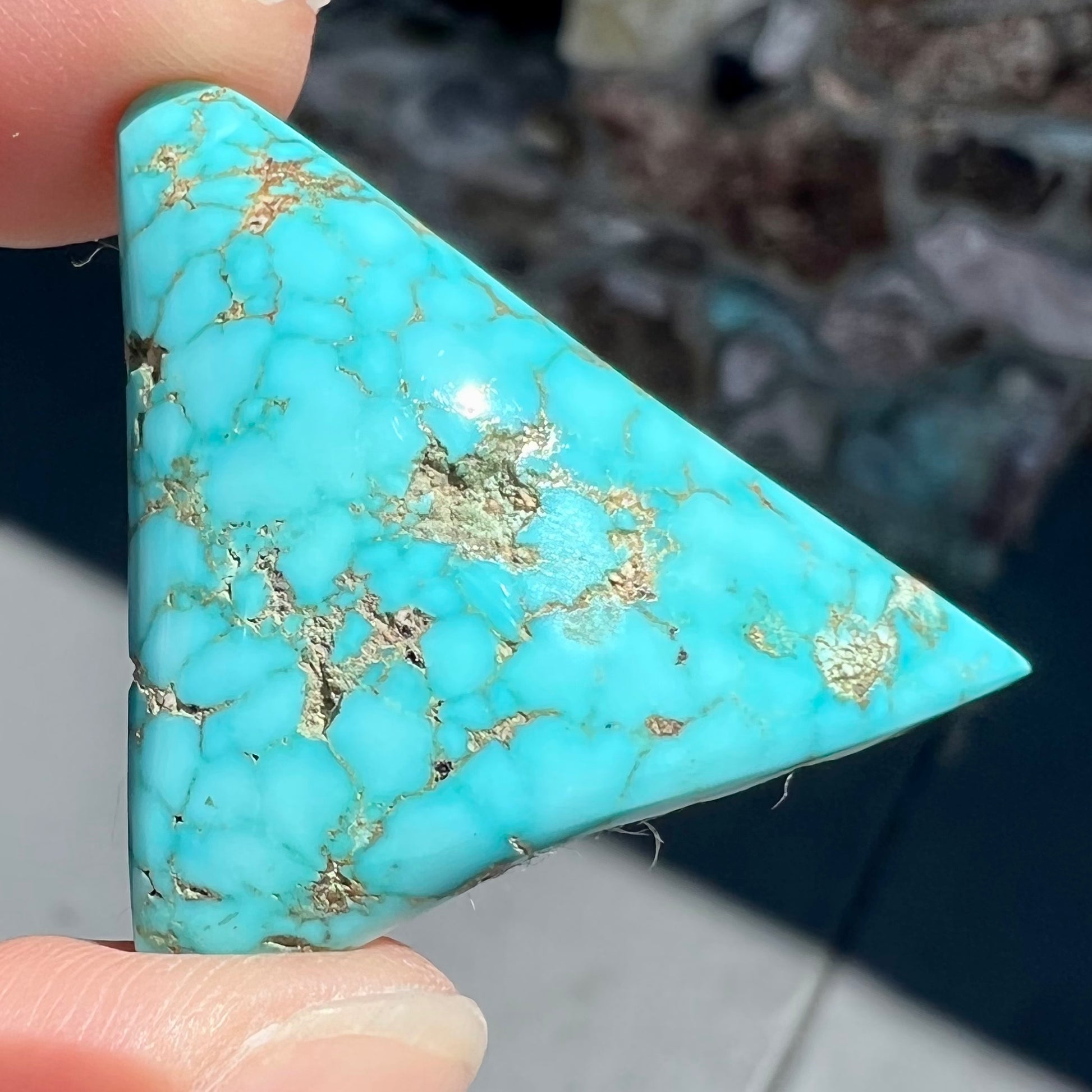A polished triangular specimen of Bisbee, Arizona turquoise.