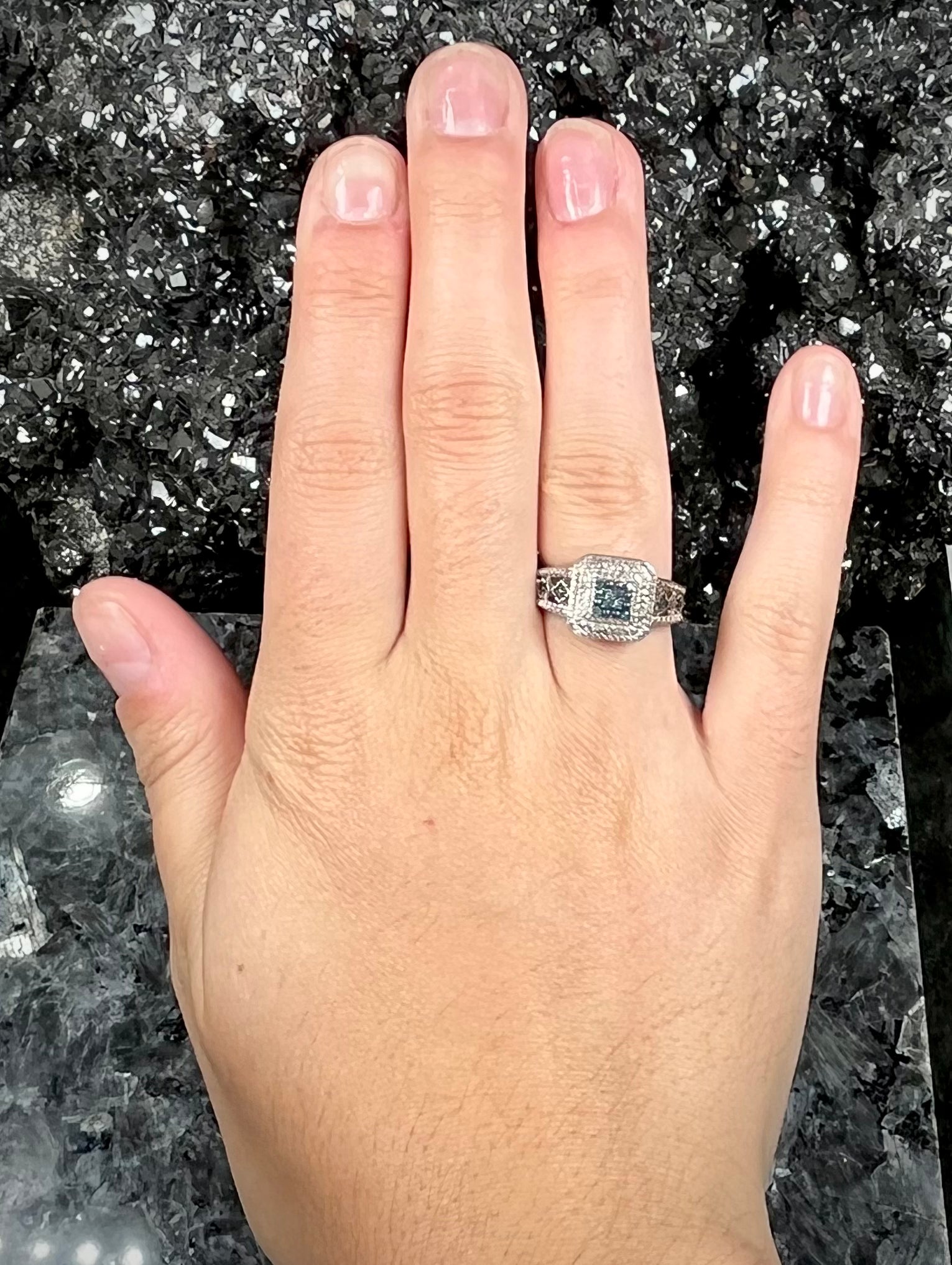 A sterling silver ring set with blue and white diamonds.