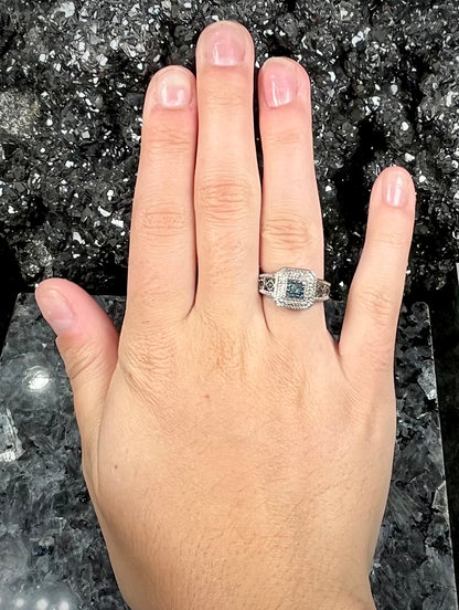 A sterling silver ring set with blue and white diamonds.