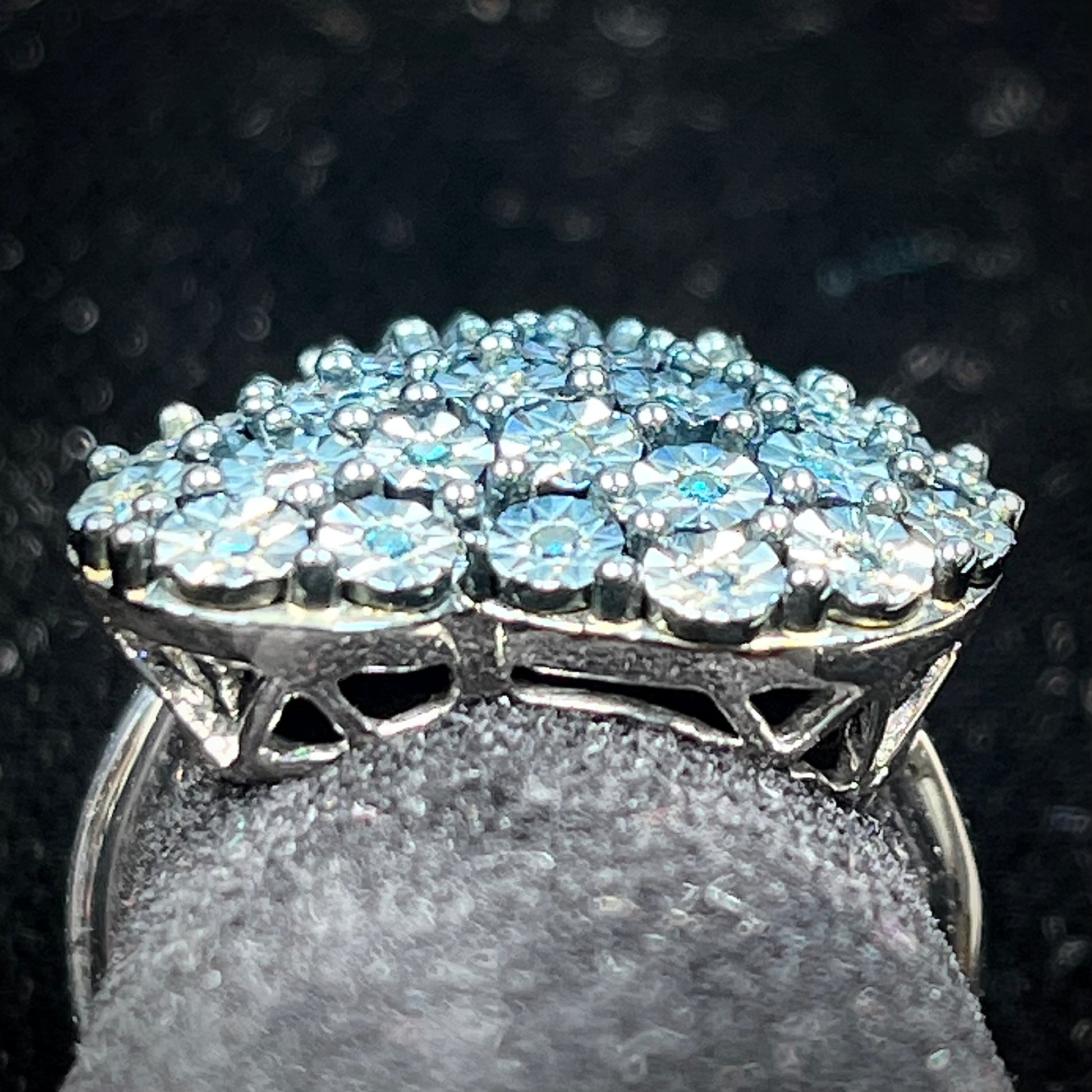 A sterling silver heart ring set with blue diamonds.