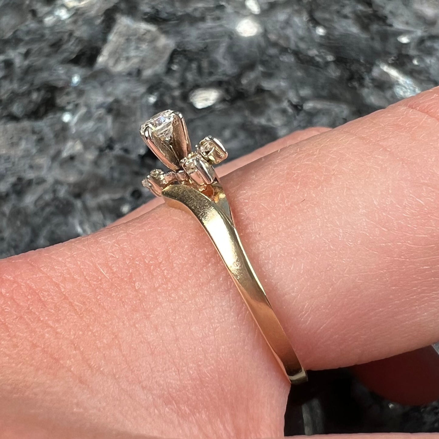 A yellow gold high-set diamond ring with four side diamonds.