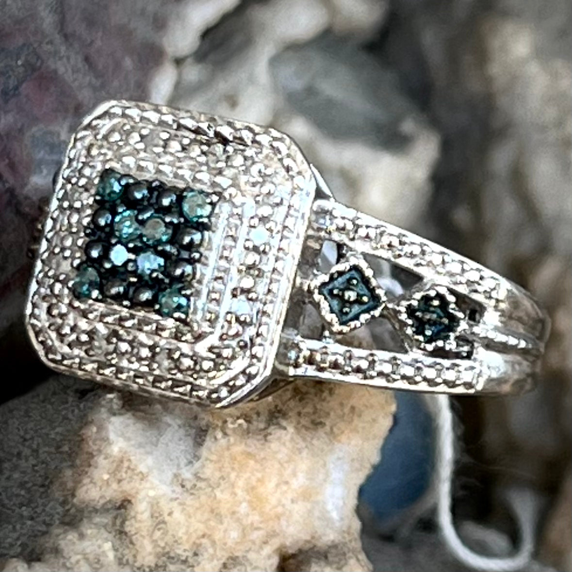 A sterling silver ring set with blue and white diamonds.