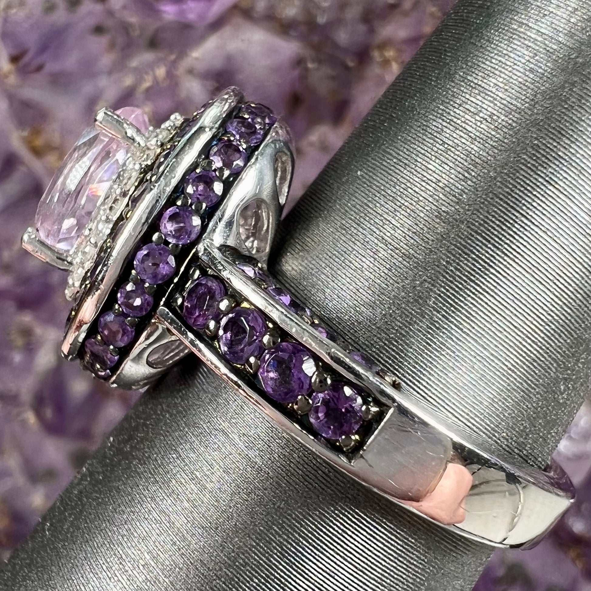 A sterling silver oval cut kunzite ring set with a double halo of round cut CZ and amethysts.