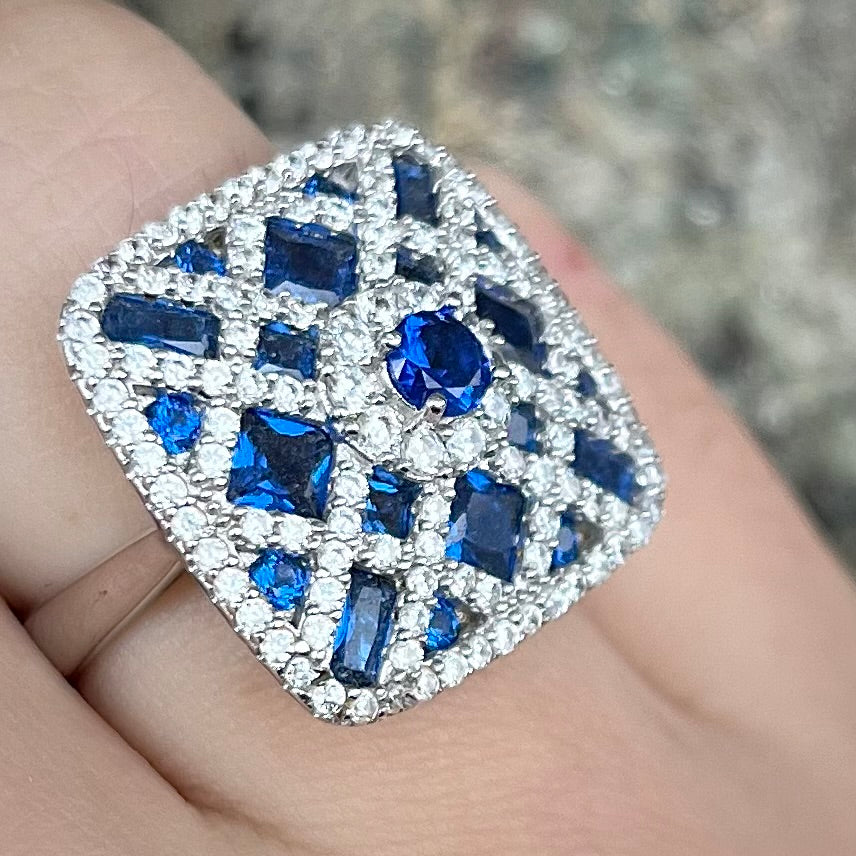 A sterling silver blue and white synthetic stone ring.  The ring strongly resembles a blueberry pie.