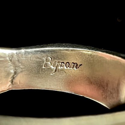A sterling silver ring inlaid with a piece of lapis lazuli.  A small crack runs through the piece of lapis.