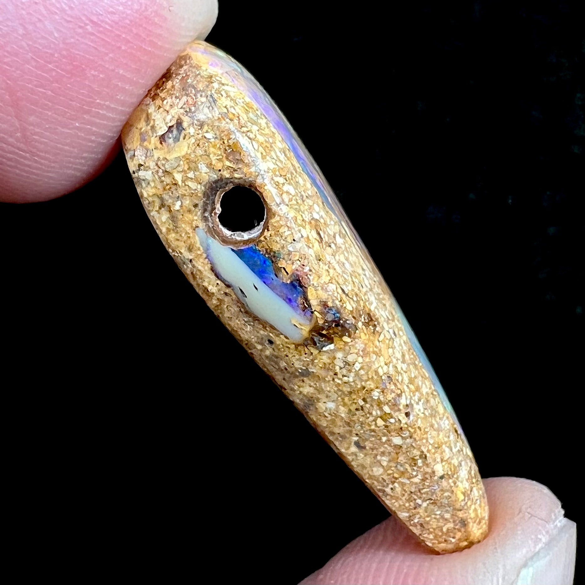 A polished, drilled pipe boulder opal bead.