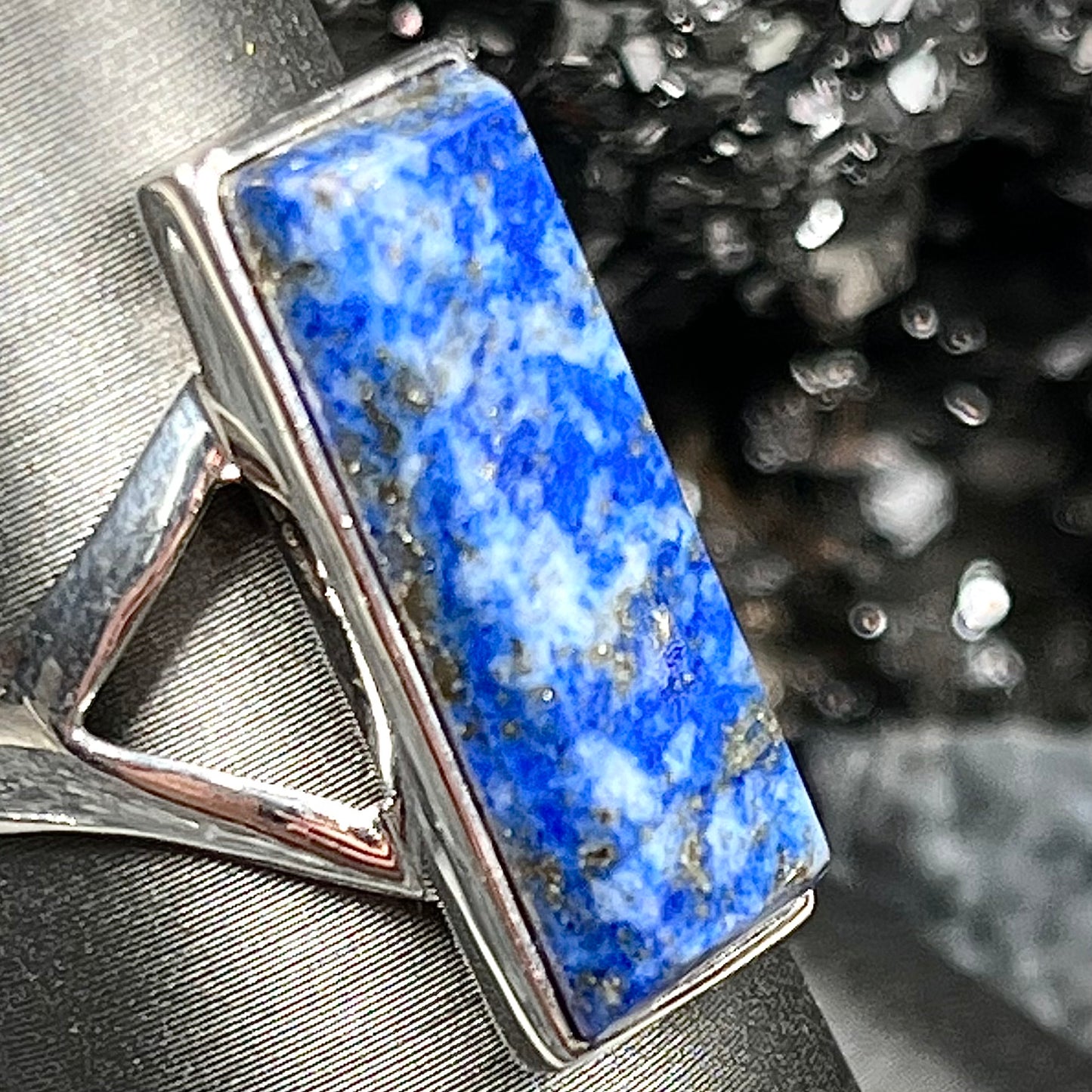 A split shank silver rectangular cabochon cut lapis lazuli ring.