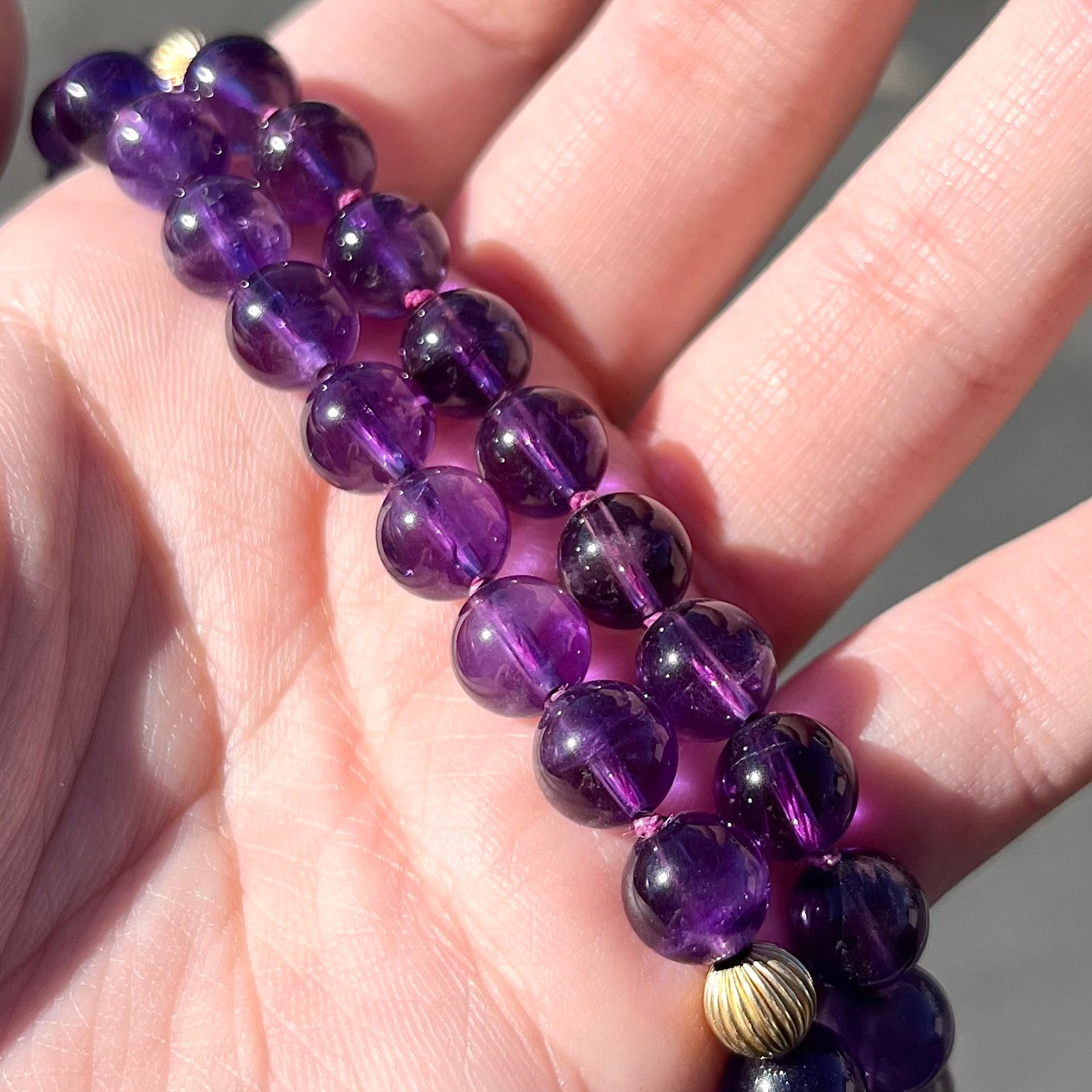 A beaded necklace made with round amethyst and 14k yellow gold beads.