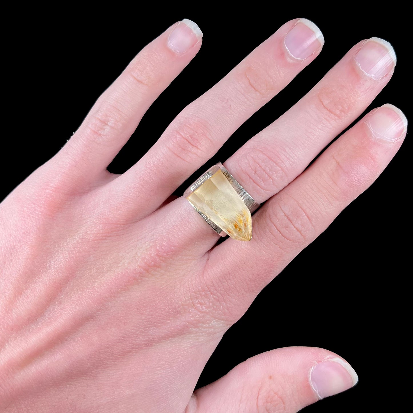 A sterling silver ring set with a naturally terminated yellow citrine quartz crystal.