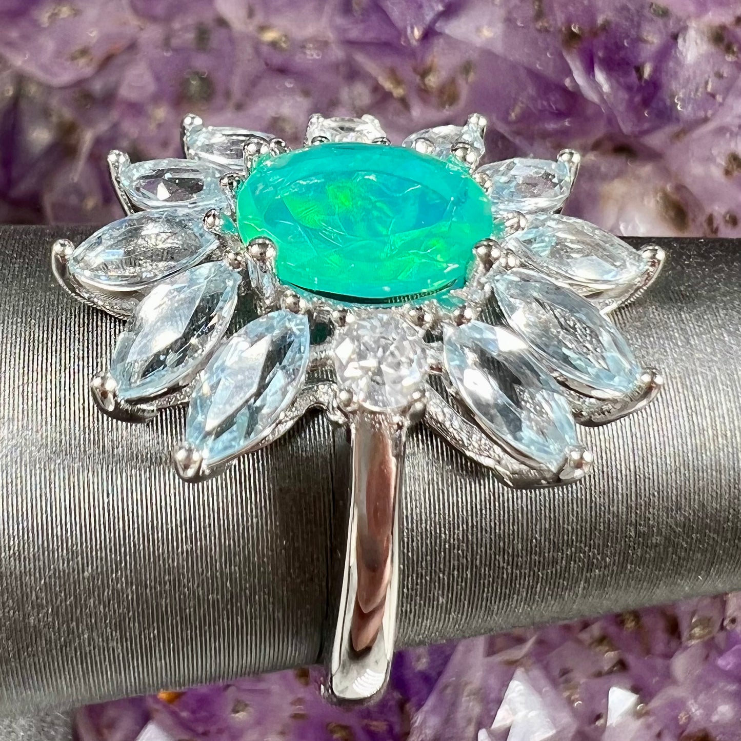 A faceted oval cut blue Ethiopian fire opal set in a sterling silver ring with marquise cut blue topaz stones.