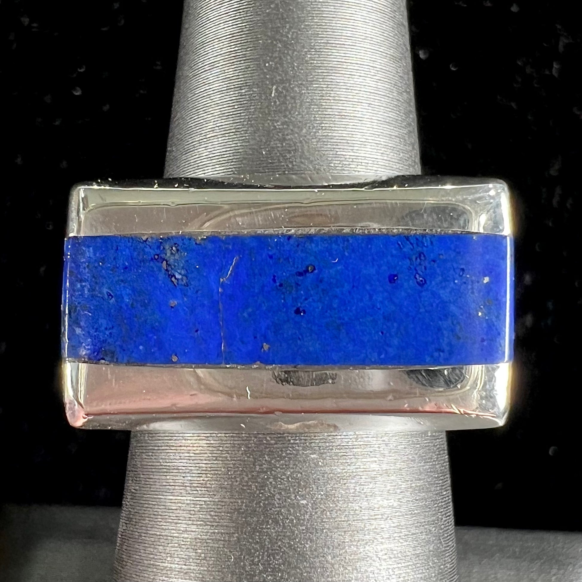A sterling silver ring inlaid with a piece of lapis lazuli.  A small crack runs through the piece of lapis.