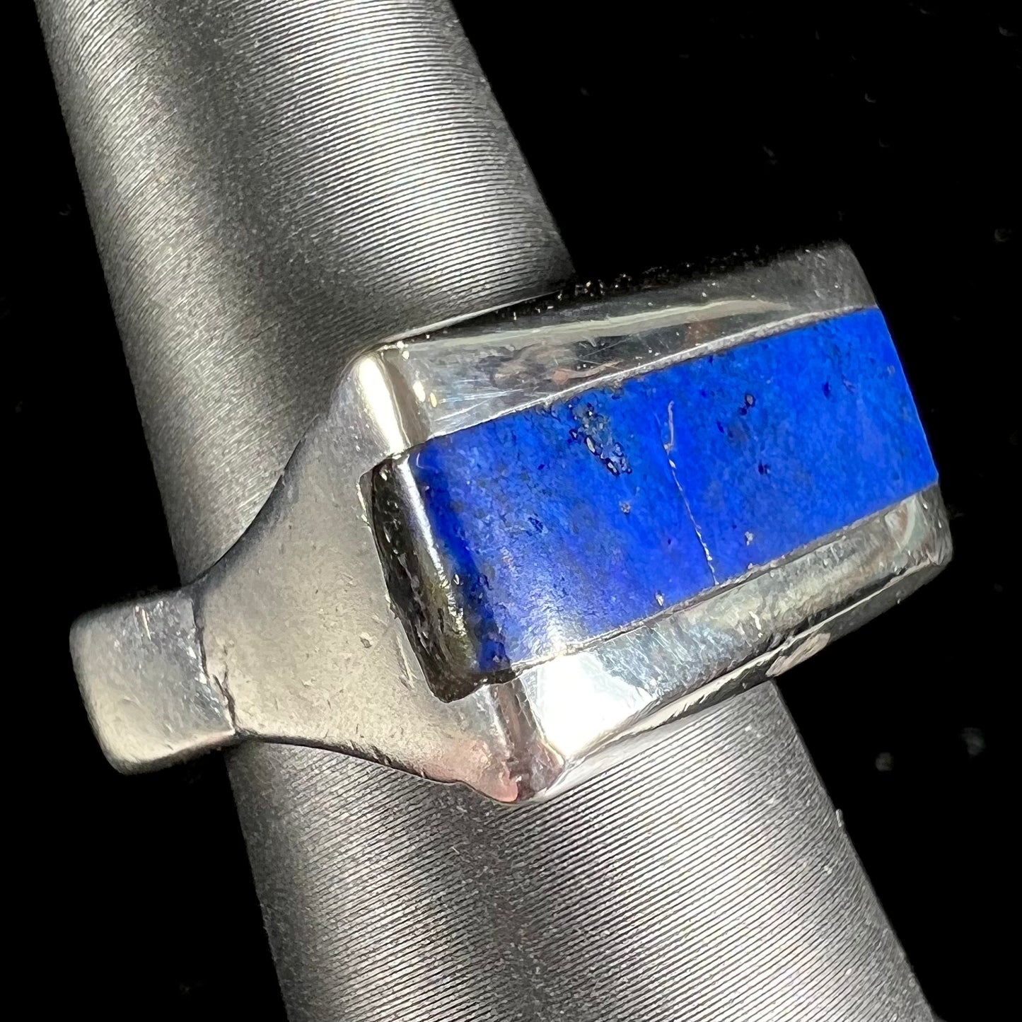 A sterling silver ring inlaid with a piece of lapis lazuli.  A small crack runs through the piece of lapis.