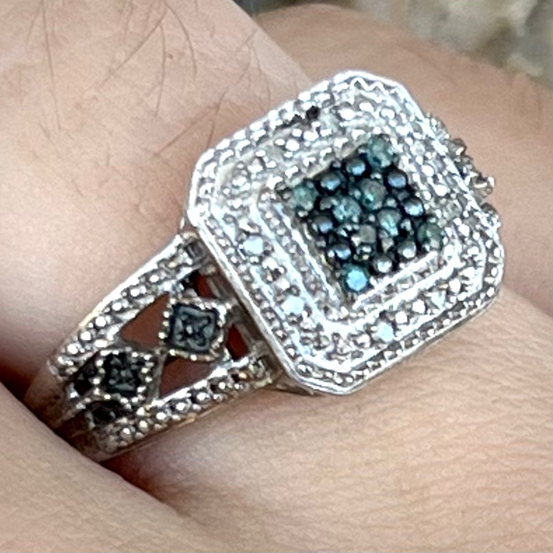 A sterling silver ring set with blue and white diamonds.