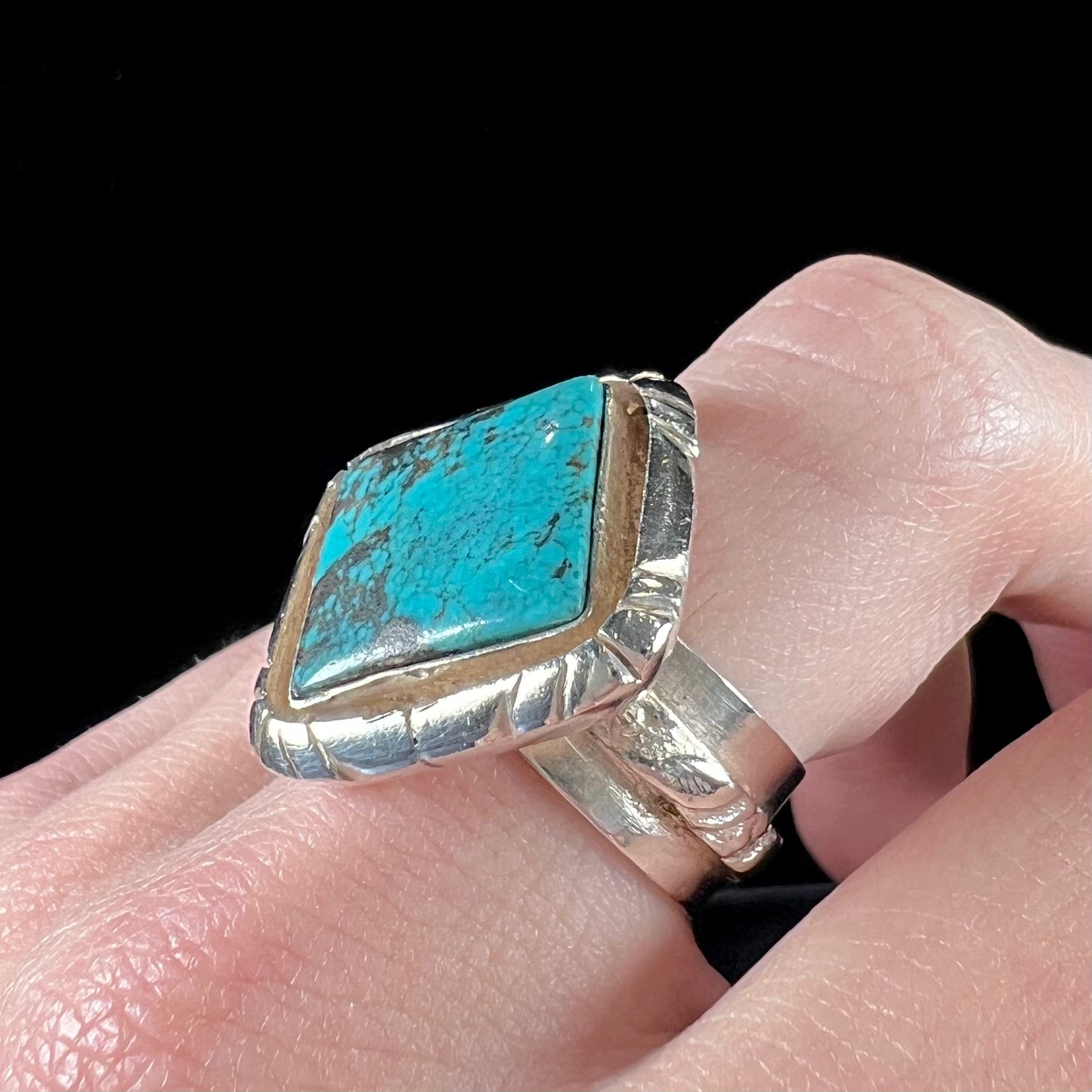 A handmade sterling silver, unisex, likely Navajo ring set with Tibetan turquoise.